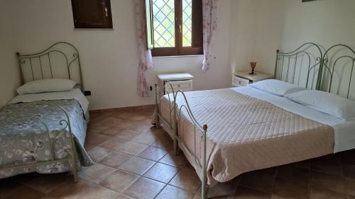 a bedroom with two beds and a window at Capocanto Rooms in Camerota