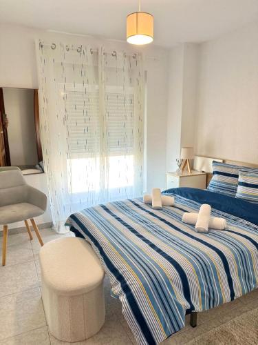 a bedroom with a large bed and a chair at Fantastic Seaview Apartment in Alicante