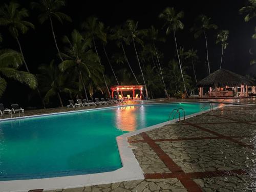 a swimming pool at a resort at night at Vista paraiso in La Puntica de Juan Dolio