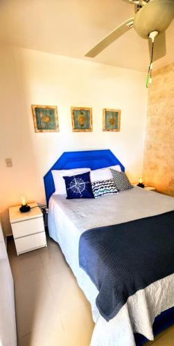 a bedroom with a large bed with a blue headboard at Vista paraiso in La Puntica de Juan Dolio