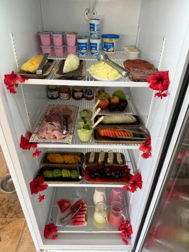 a refrigerator filled with lots of different types of food at Pousada Vila Canoa in Canoa Quebrada