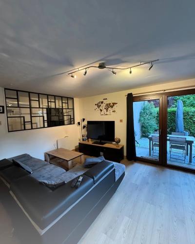 - un salon avec un grand canapé et une télévision dans l'établissement Greenloft La tonnelle, à Annecy