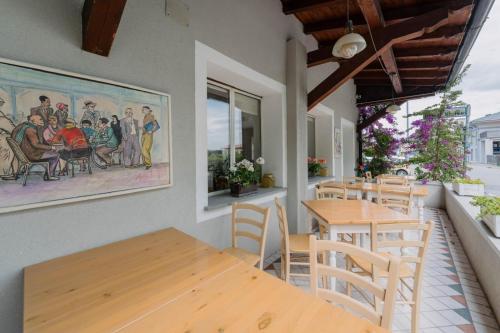 a restaurant with tables and chairs and a painting on the wall at Franciacorta Rooms 1 in Corte Franca