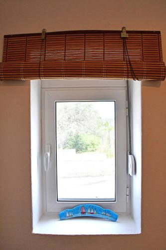 a window in a room with a blind at Da Vinci kavouropetra in Aegina Town