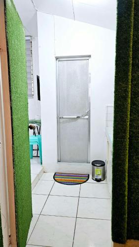 a white hallway with a door to a refrigerator at Happy Homes Guest House in Legazpi