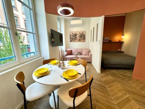 une salle à manger avec une table et des chaises blanches dans l'établissement Lumiere - Chic cocoon au coeur de lyon, à Lyon