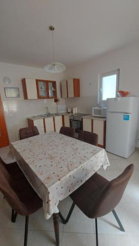 a kitchen with a table and some chairs and a table and a kitchen at Apartman Tija in Orebić