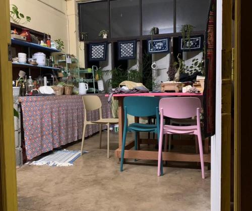 Kampong HuaibūYor Song Hostel Pai的厨房里有一张粉色桌子和四把椅子