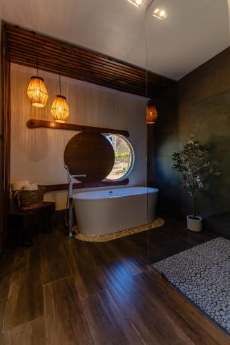 a bath tub in a room with a window at Brisa Del Valle Hotel Boutique in Valle de Guadalupe