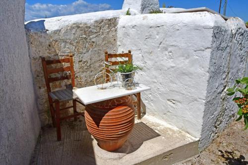 a table and two chairs and a table with a plant at Da Vinci kavouropetra in Aegina Town