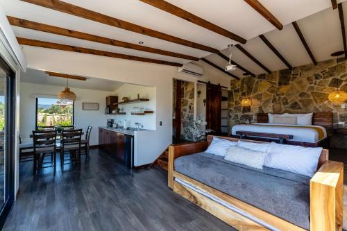 a bedroom with a bed and a kitchen with a table at Brisa Del Valle Hotel Boutique in Valle de Guadalupe