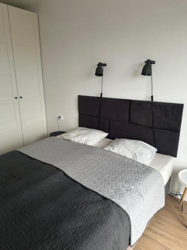 a bedroom with a large bed with a black headboard at ORKAN 2 in Kuźnica