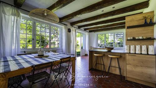 - une cuisine avec une table et quelques fenêtres dans l'établissement La Maison des Plages Concarneau, à Concarneau