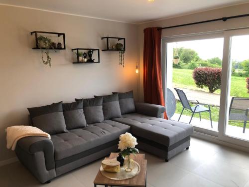 un salon avec un canapé et une grande fenêtre dans l'établissement Joy at Durbuy, à Durbuy