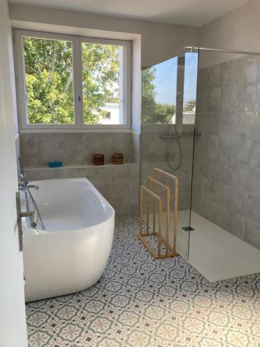 une grande salle de bain avec baignoire et douche dans l'établissement La Maison des Plages Concarneau, à Concarneau