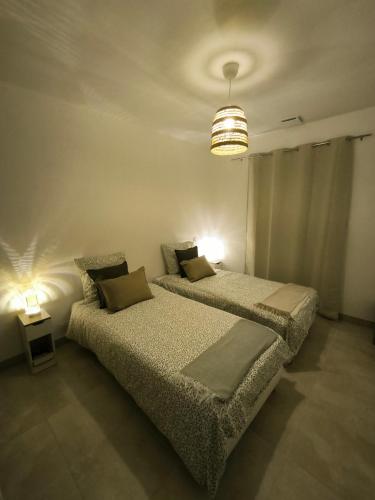 - une chambre avec 2 lits et un éclairage dans l'établissement Beautiful villa between Uzès & Avignon, à Saint-Marcel-de-Carreiret