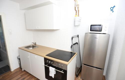 Una pequeña cocina con nevera y fregadero. en BEGE APARTMENTS StayForWork, en Hagen