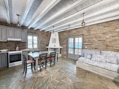 a kitchen and dining room with a table and a couch at The Traditional Stone Villa in Koundouros
