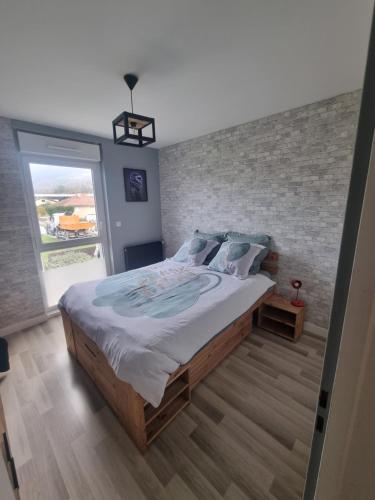 una camera con un grande letto con un muro di mattoni di Chambre avec vue chez l'habitant a Saint Pierre en Faucigny