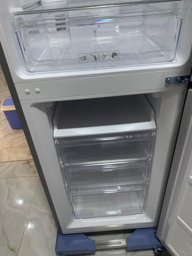 an empty refrigerator with its door open in a kitchen at Beau-Séjour in Dogar
