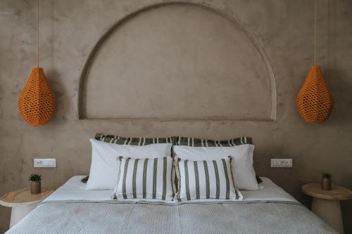 a bedroom with a bed with striped pillows at Athera Suites Mykonos in Tagou