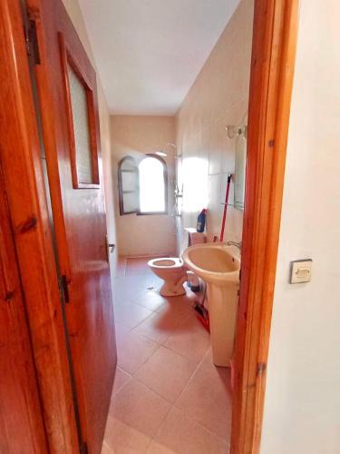 ein Badezimmer mit zwei Toiletten und einem Waschbecken in der Unterkunft خليل in Oulad Akkou