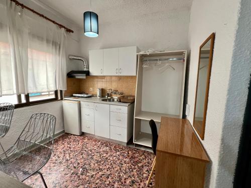 a small kitchen with a refrigerator and a sink at PELEKAN rooms and apartments Athina 33 in Pefkohori