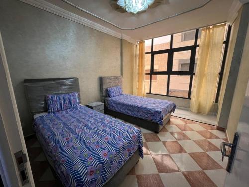 a bedroom with two beds and a window at Appartement 1 luxueux vue mer in Al Hoceïma