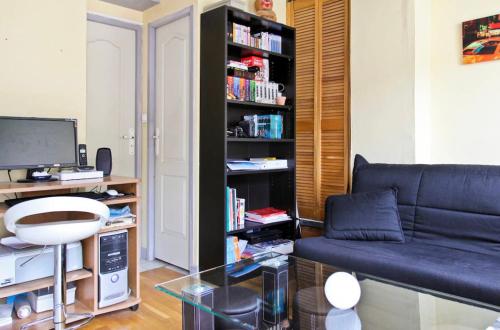 un salon avec un canapé et une étagère dans l'établissement Studio climatisé au calme, terrasse vue colline, à Nice