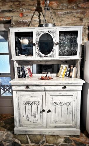 a white cabinet with a microwave on top of it at The Traditional Stone Villa in Koundouros