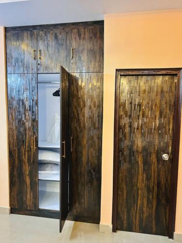 a room with two wooden doors next to a wall at Acacia Apartment 707 in Lucknow