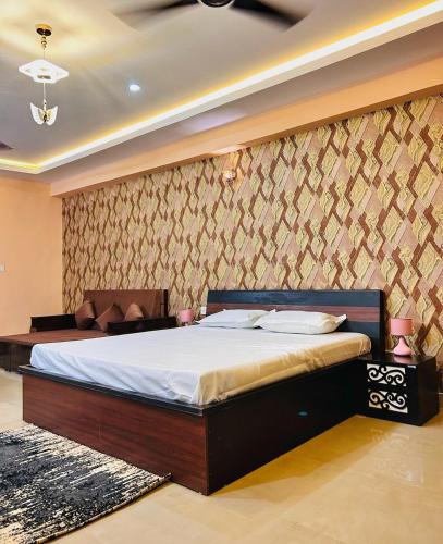 a bedroom with a bed in a room with a wall at Acacia Apartment 707 in Lucknow