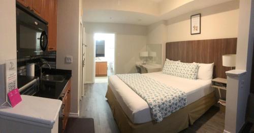 a bedroom with a large bed and a kitchen at Universal-Disney Dream 606H Studio - The Point in Orlando