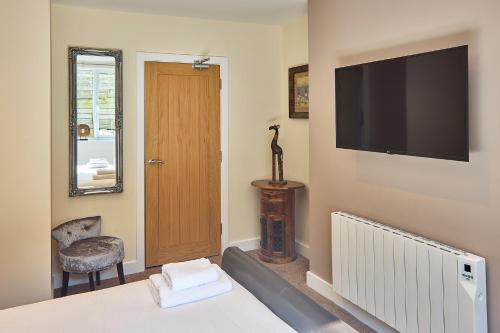 a bedroom with a bed and a flat screen tv at Aaron Accommodation in Whitby