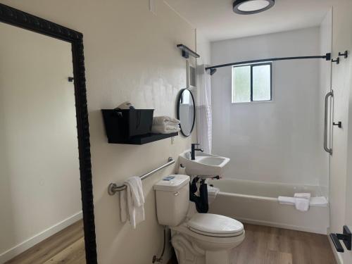 a white bathroom with a toilet and a sink at Richland Inn and Suites in Richland