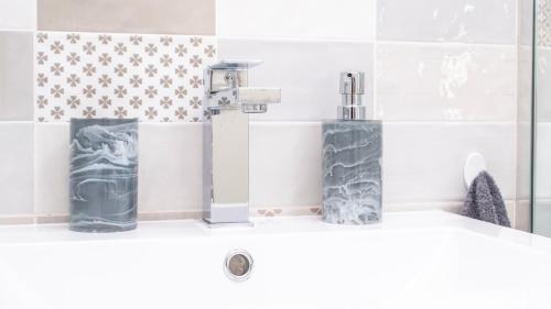 a bathroom sink with two bottles and a faucet at Sea Breeze Apartment in Wilderness