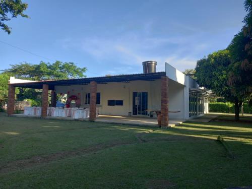 a house with a pavilion in front of a yard at Casablanca de Sirivana in Yopal