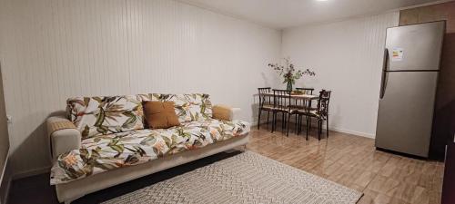 a living room with a couch and a refrigerator at Cabañas Teave in Hanga Roa