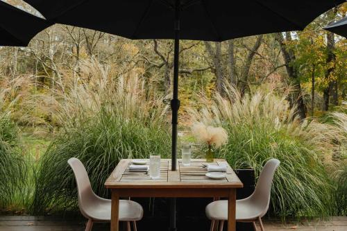 a wooden table with two chairs and an umbrella at Suite 001 in Kenoza Lake
