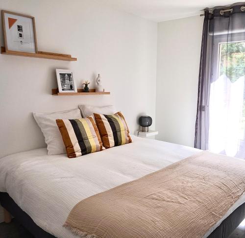 une chambre avec un grand lit blanc avec des oreillers dans l'établissement Marseille Longchamp, à Marseille