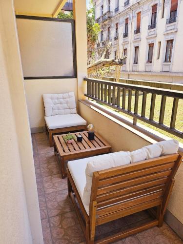 d'un balcon avec deux bancs, une table et une fenêtre. dans l'établissement T2 avec balcon - Rue Royale 5min du Lac, à Annecy