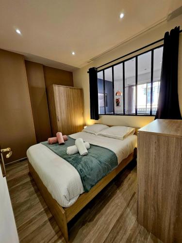 une chambre avec un lit avec deux serviettes dessus dans l'établissement T2 avec balcon - Rue Royale 5min du Lac, à Annecy