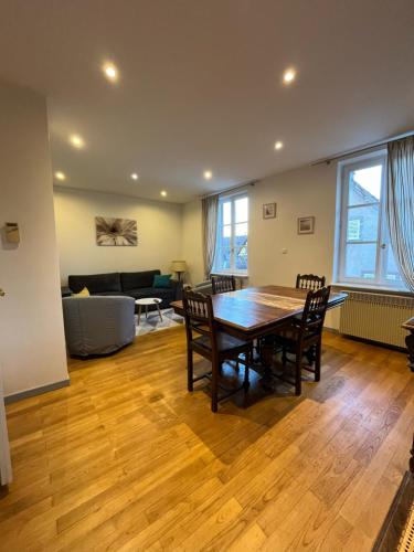 un salon avec une table et des chaises en bois dans l'établissement Bim Katele, à La Celle-sous-Gouzon