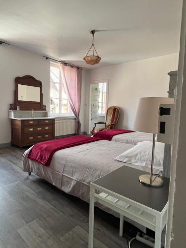 une chambre avec deux lits, une commode et un miroir dans l'établissement Bim Katele, à La Celle-sous-Gouzon