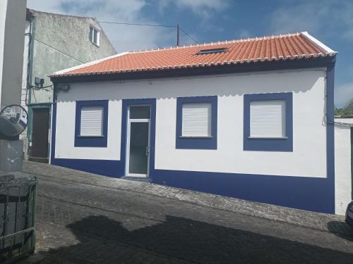 a blue and white building with a red roof at Casa de Pyrus in Angra do Heroísmo
