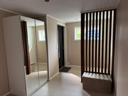 a hallway with a mirror and a chair in a house at Leilighet på Harøya in Ålesund