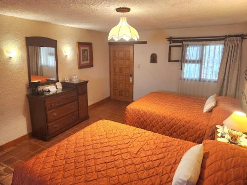 a hotel room with two beds and a mirror at El Meson de los Poetas in Guanajuato