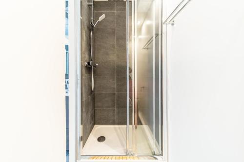 une douche avec une porte vitrée dans une salle de bain dans l'établissement T5 balcony Parking 10 min Eurexpo -Stade-ldlc, à Bron