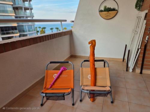 two chairs sitting on a balcony with a view of the ocean at Costa Marina III - 1ª línea de playa in El Borseral
