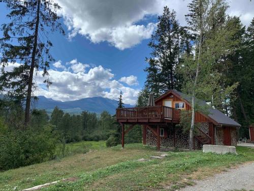 ein Haus mit einer Terrasse an der Seite eines Hügels in der Unterkunft Entire Cordwood House 5 minutes south of town in Golden